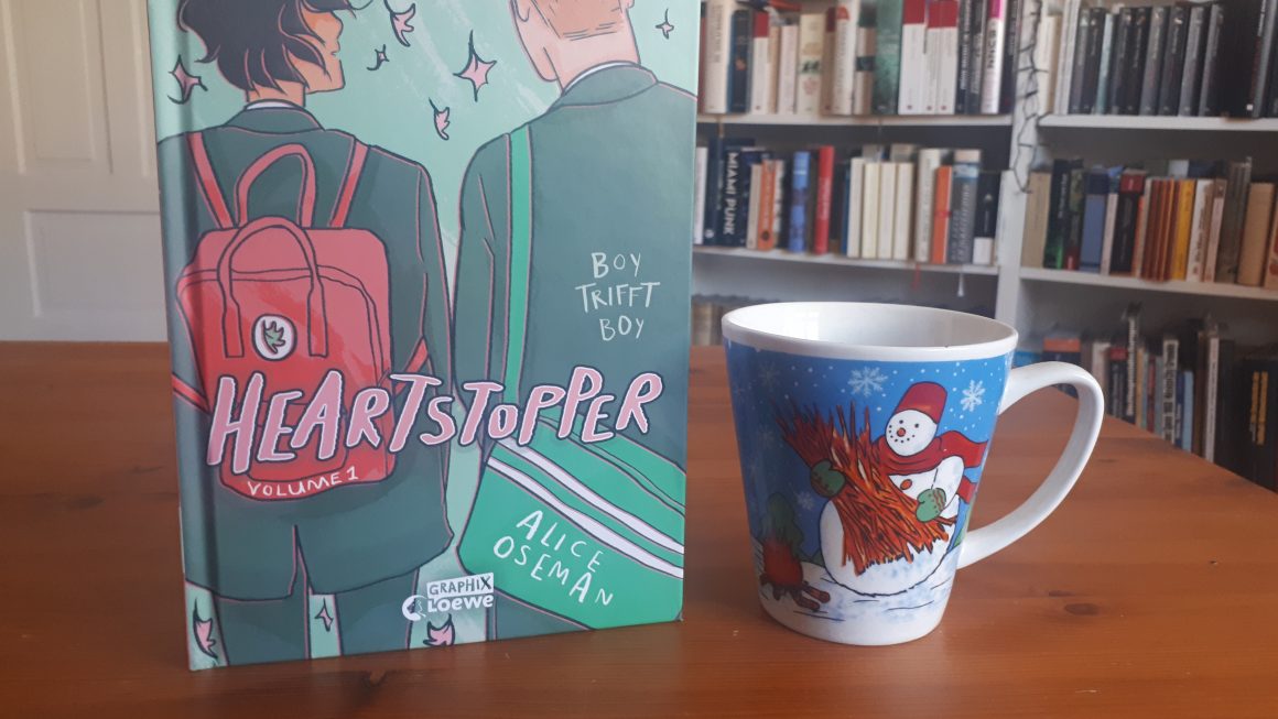 Das Bild zeigt das Buch "Heartstopper" von Alice Oseman und die Schneemanntasse.