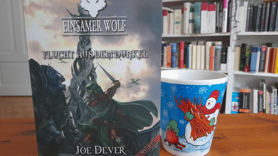 Das Bild zeigt das Buch "Einsamer Wolf: Flucht aus dem Dunkel" von Joe Dever. Daneben steht die Schneemanntasse.