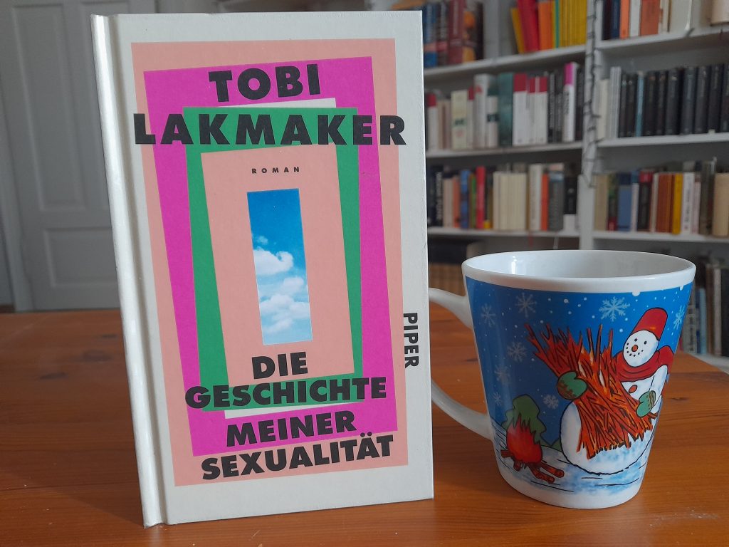 Das Bild zeigt das Buch "Die Geschichte meiner Sexualität" von Tobi Lakmaker. Daneben steht die Schneemanntasse.