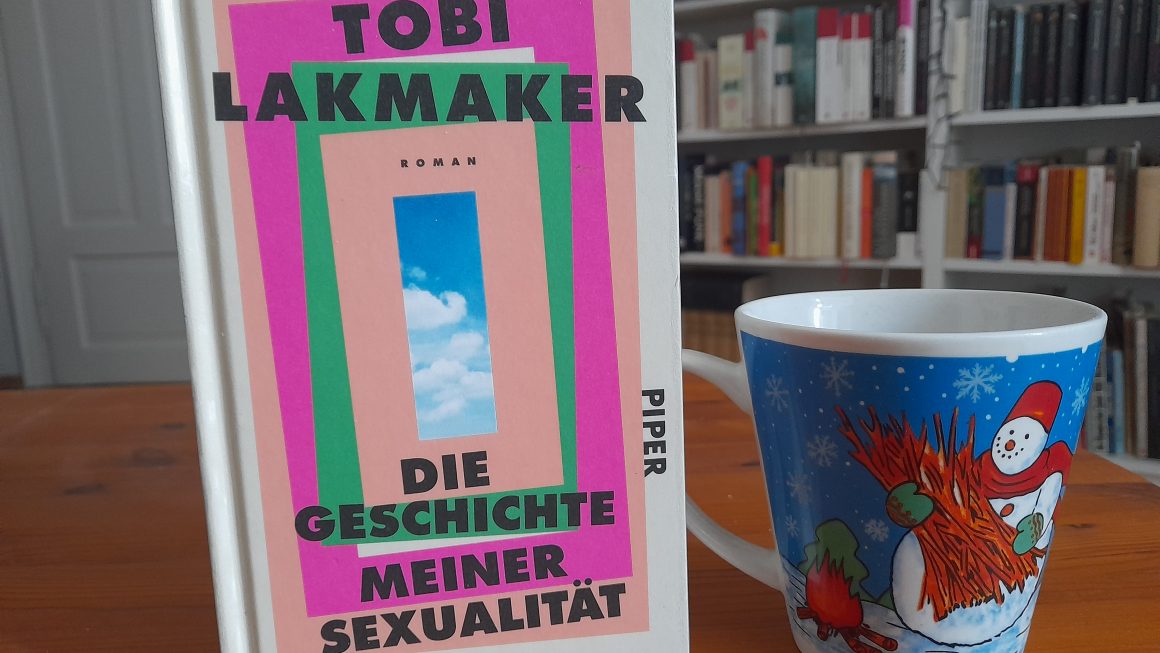 Das Bild zeigt das Buch "Die Geschichte meiner Sexualität" von Tobi Lakmaker. Daneben steht die Schneemanntasse.