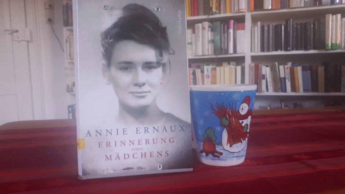 Das Buch "Erinnerung eines Mädchens" von Annie Ernaux und daneben die Schneemanntasse.